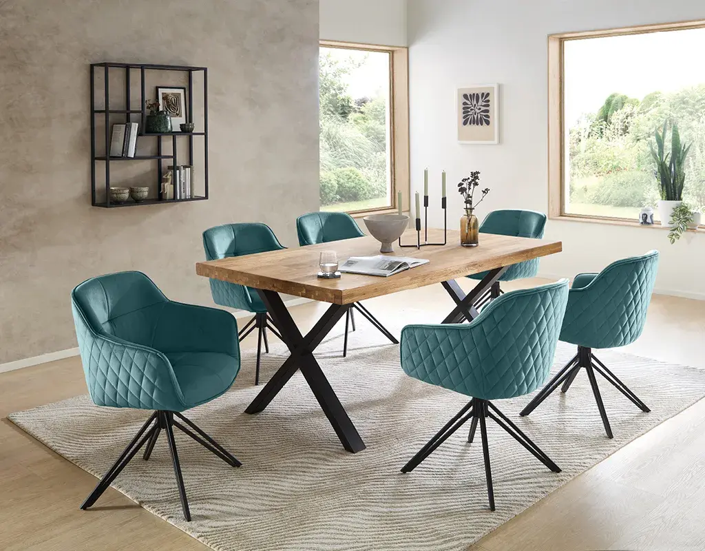 Helles Esszimmer mit großem Massivholz-Esstisch, schwarzen Metallfüßen und sechs türkisfarbenen Polsterstühlen. Modernes Design für stilvolle Essbereiche mit hohem Sitzkomfort.